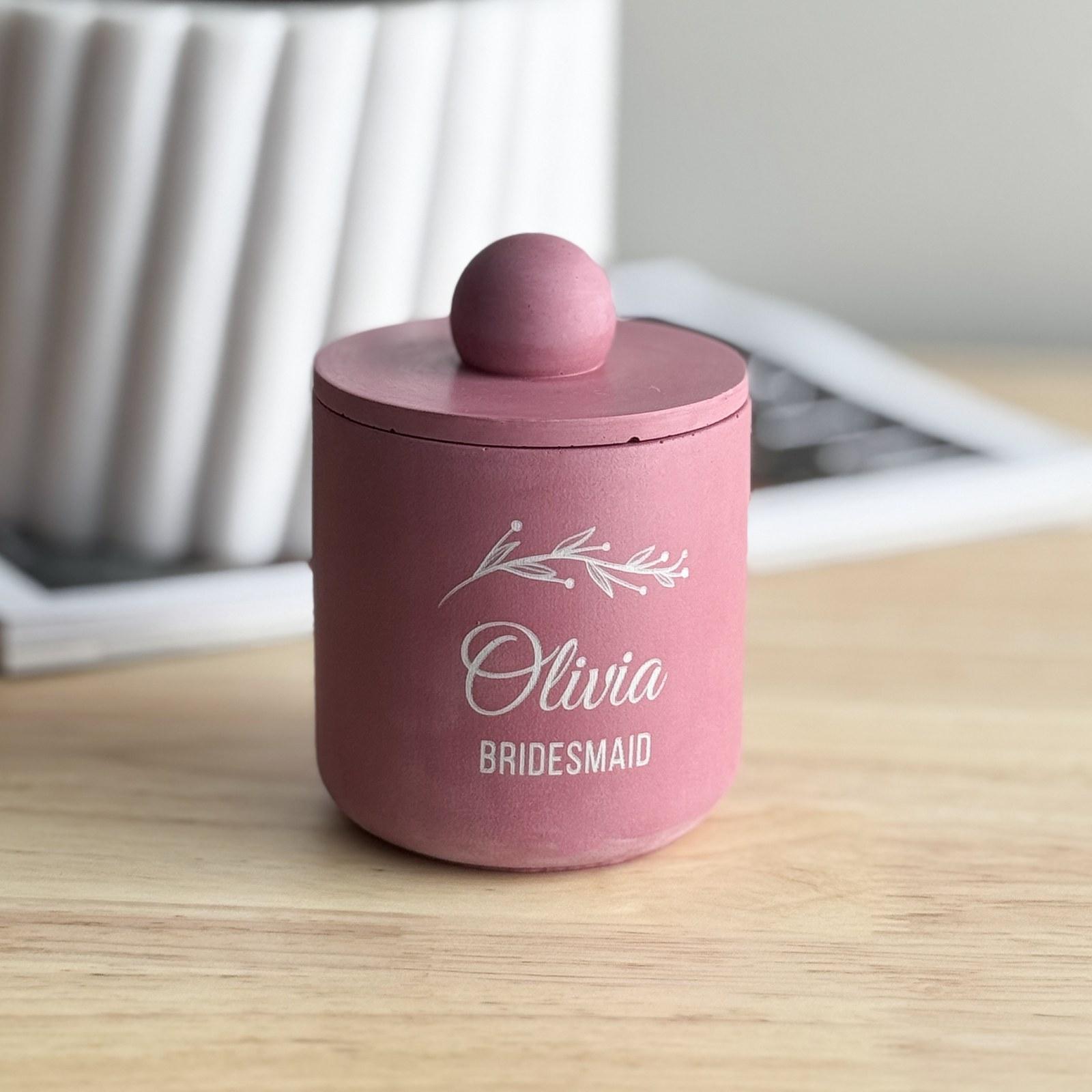 Pink concrete candle jar with a lid, engraved with a bridesmaid's name