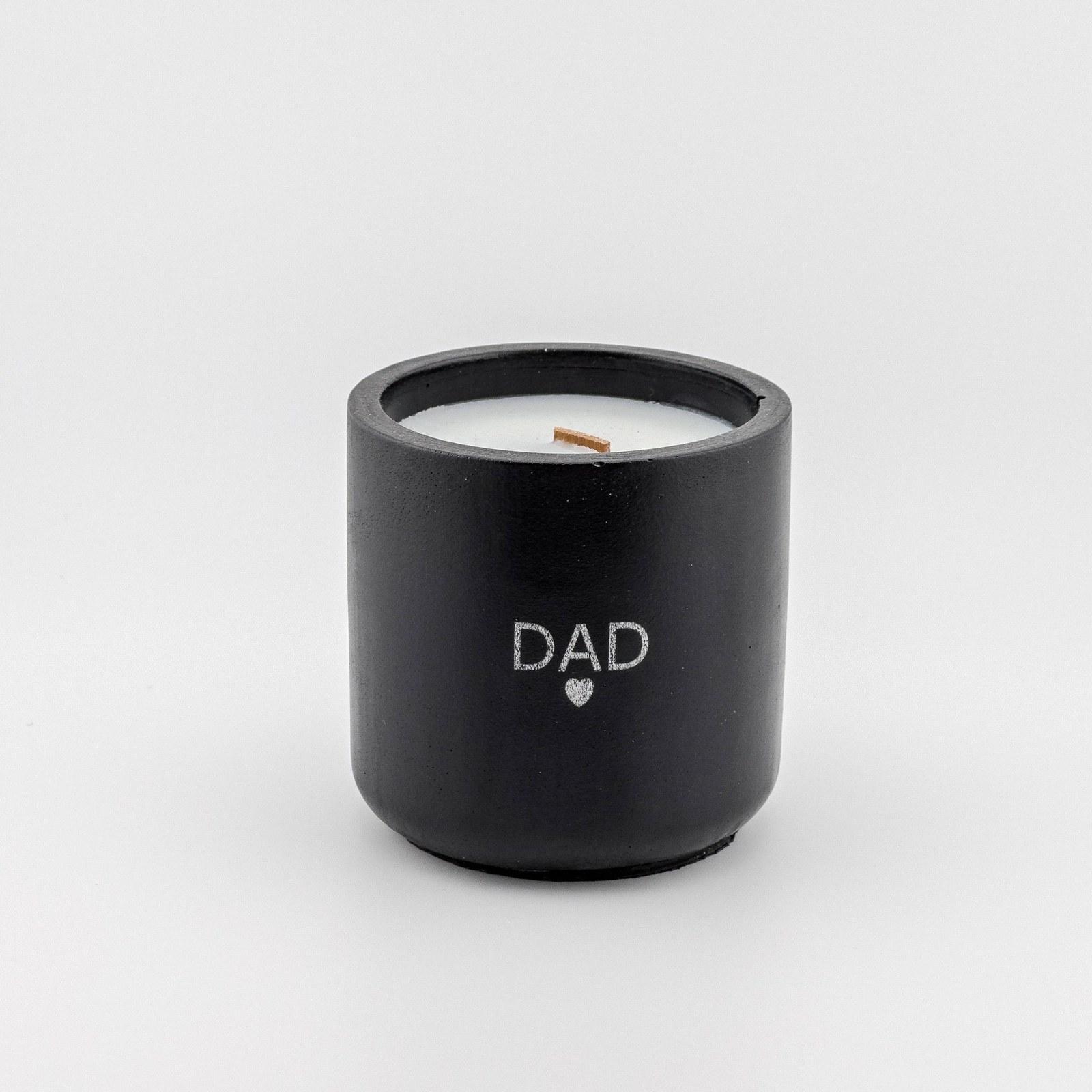 Matte black concrete candle with a wood wick, laser engraved with the word DAD and a small heart