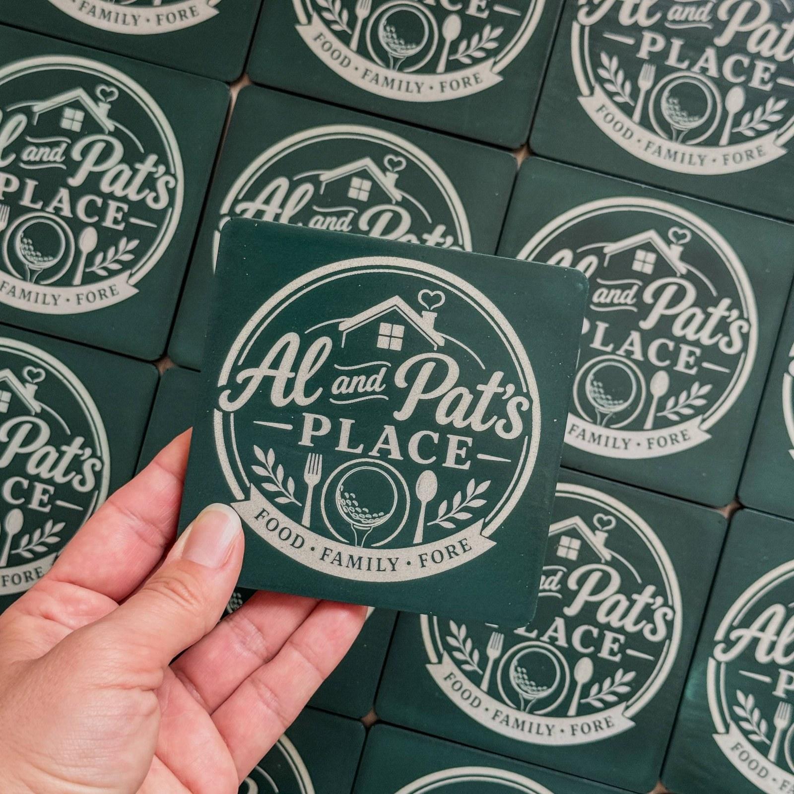 Dark green concrete coasters with an engraved restaurant logo