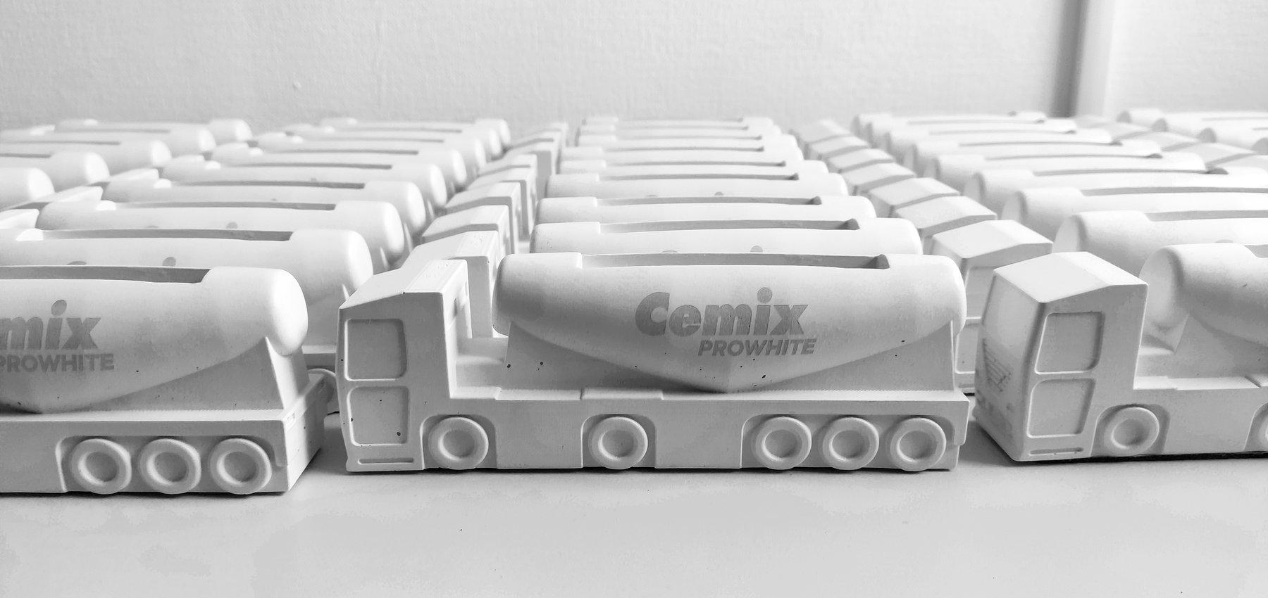 Rows of custom white concrete cement truck models branded for Cemix, made as corporate gifts by JOS Factory