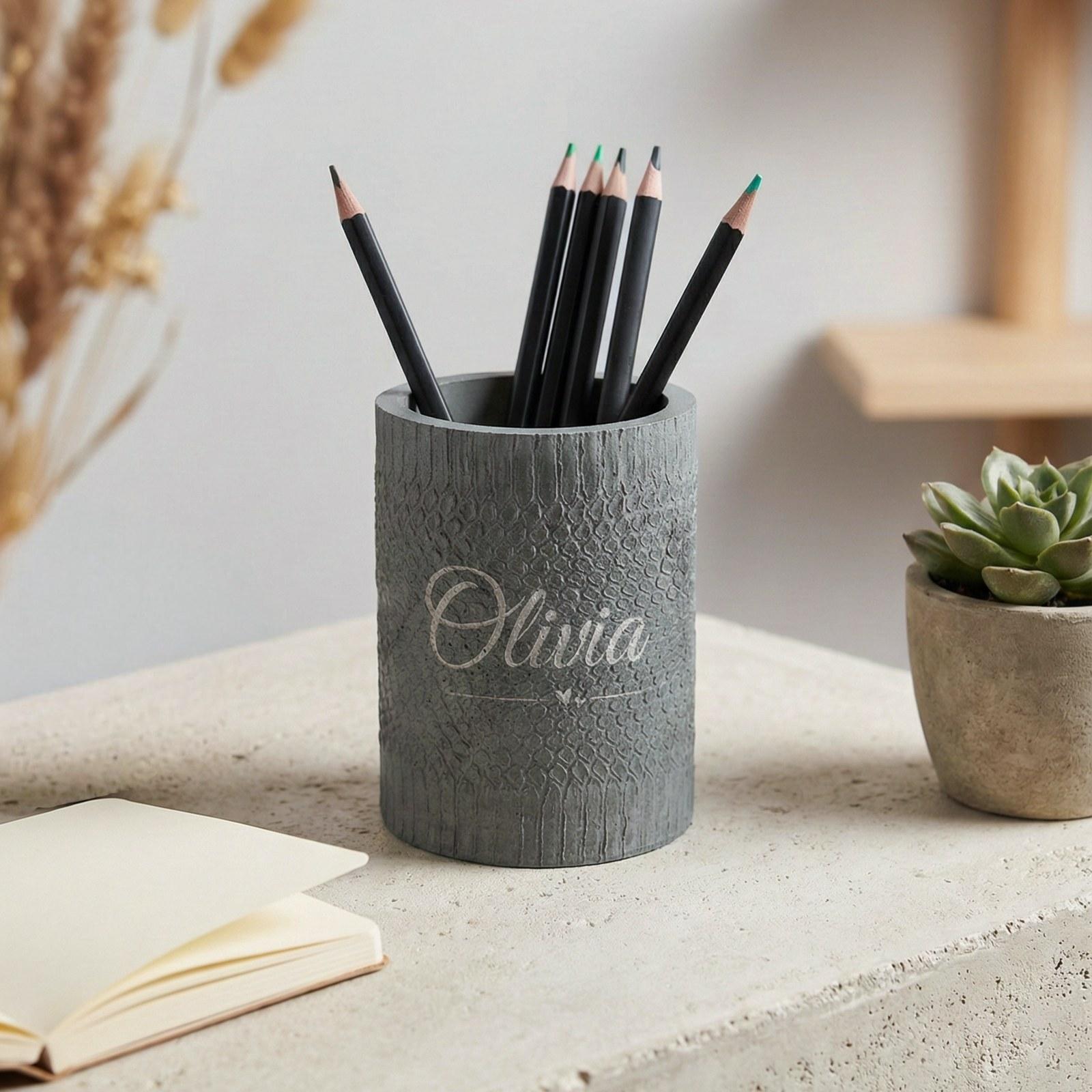 Textured grey concrete pen cup engraved with the name Olivia, holding pencils
